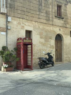 Rote Telefonzelle in einer Gasse auf Gozo, Malta
